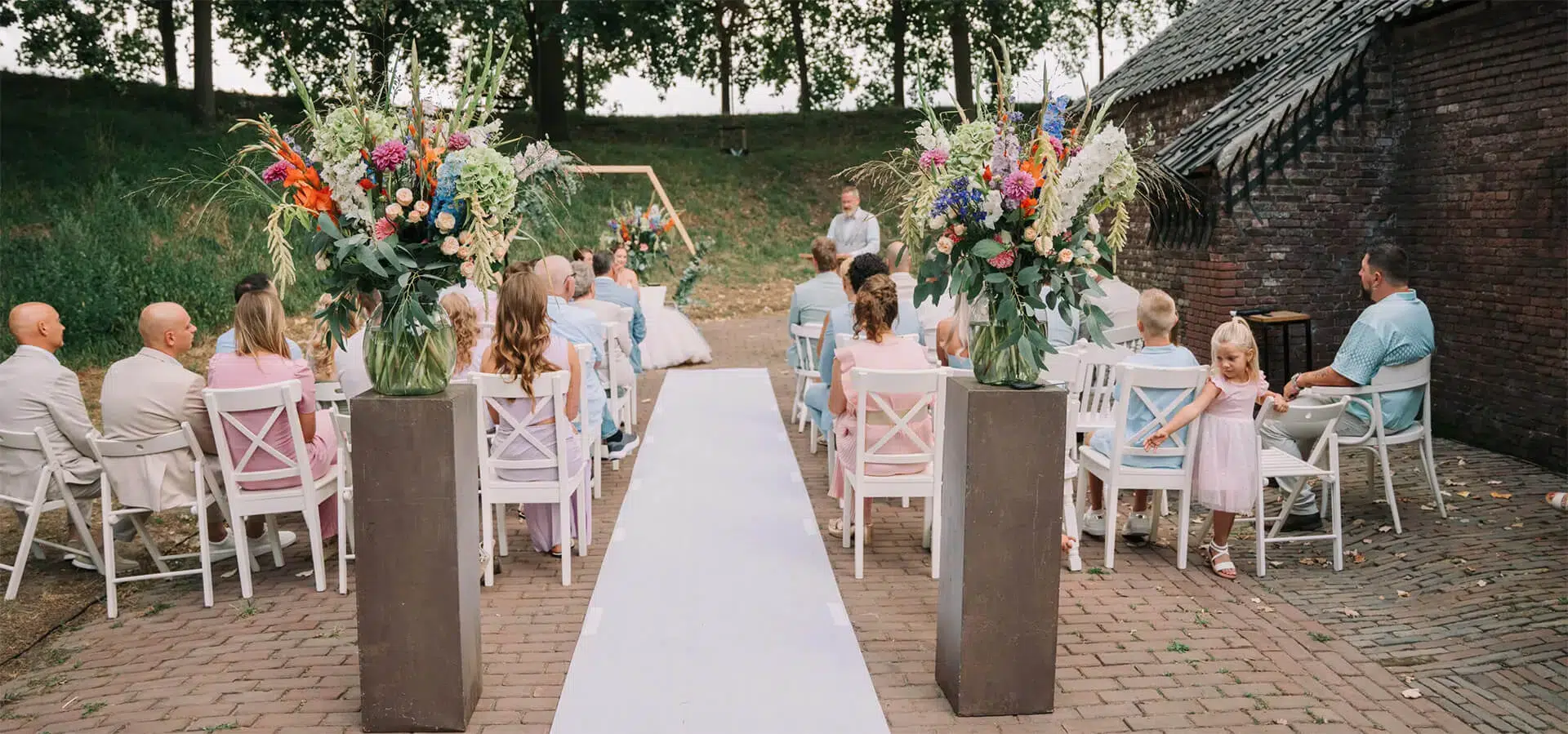 Buitenceremonie lente bruiloft omringd door bloeiende fortwallen in Brabant
